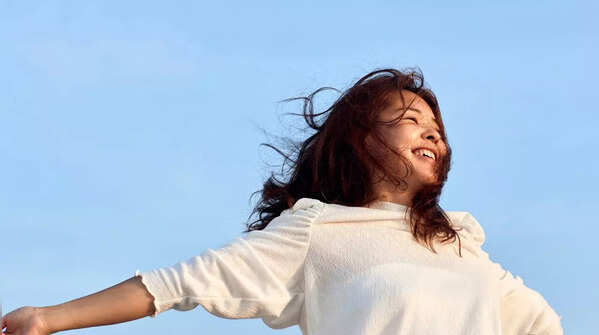 Woman meditating outdoors, symbolizing embracing the present moment.