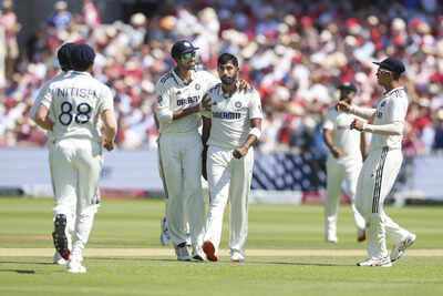 Jasprit Bumrah celebrating with teammates after taking a wicket.